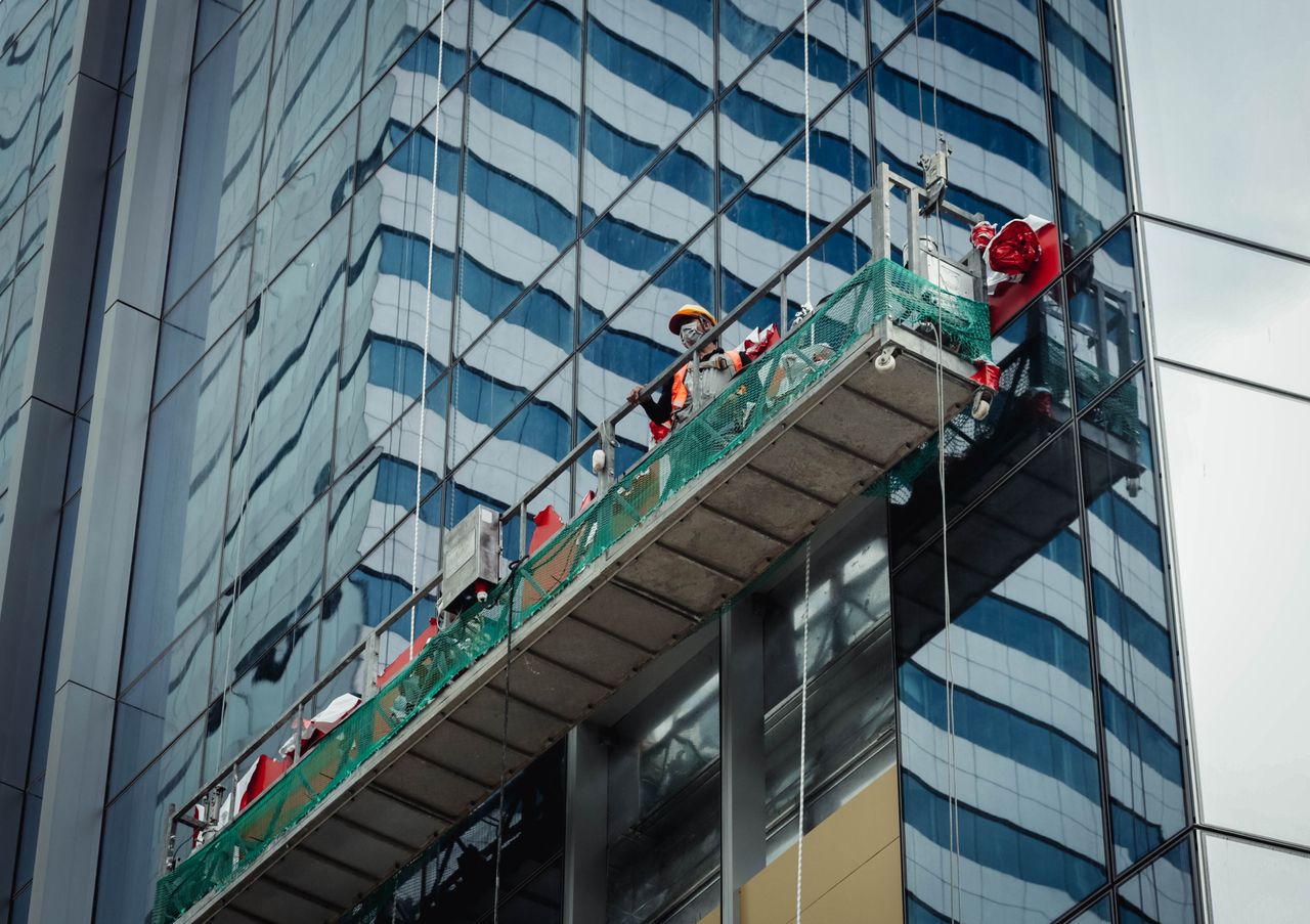 services-04 Urban worker cleaning windows on a high-rise in Ho Chi Minh City, Vietnam.